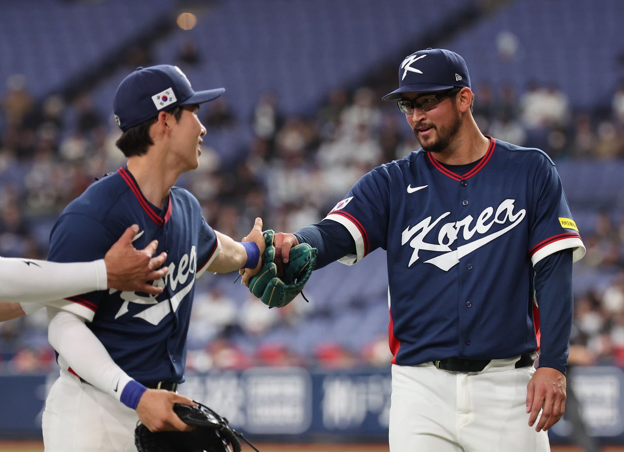 3이닝 무실점으로 호투한 뒤 김혜성(왼쪽)과 하이파이브하는 더닝. 연합뉴스