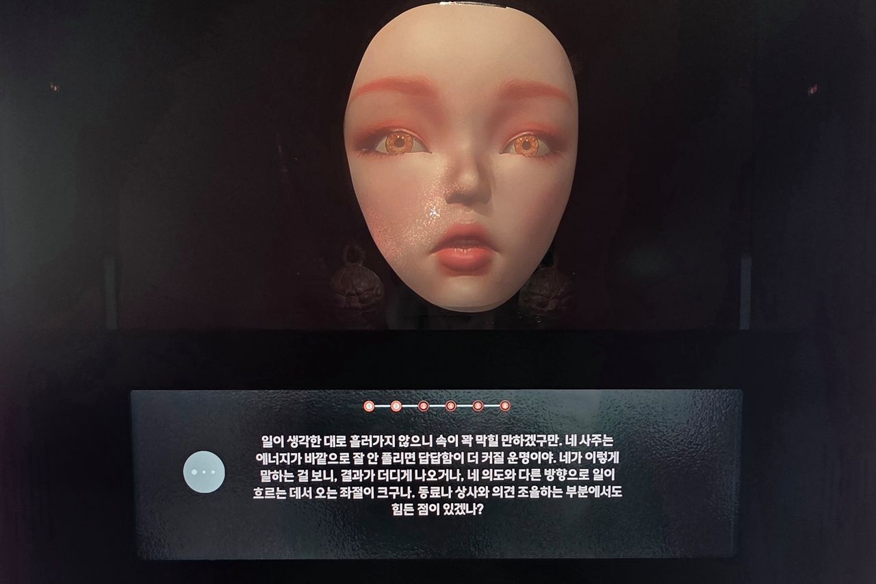 AI 무당 ‘아미’가 점괘를 알려주는 모습. 질문에 답하면 부적을 그려준다. 김창용 기자