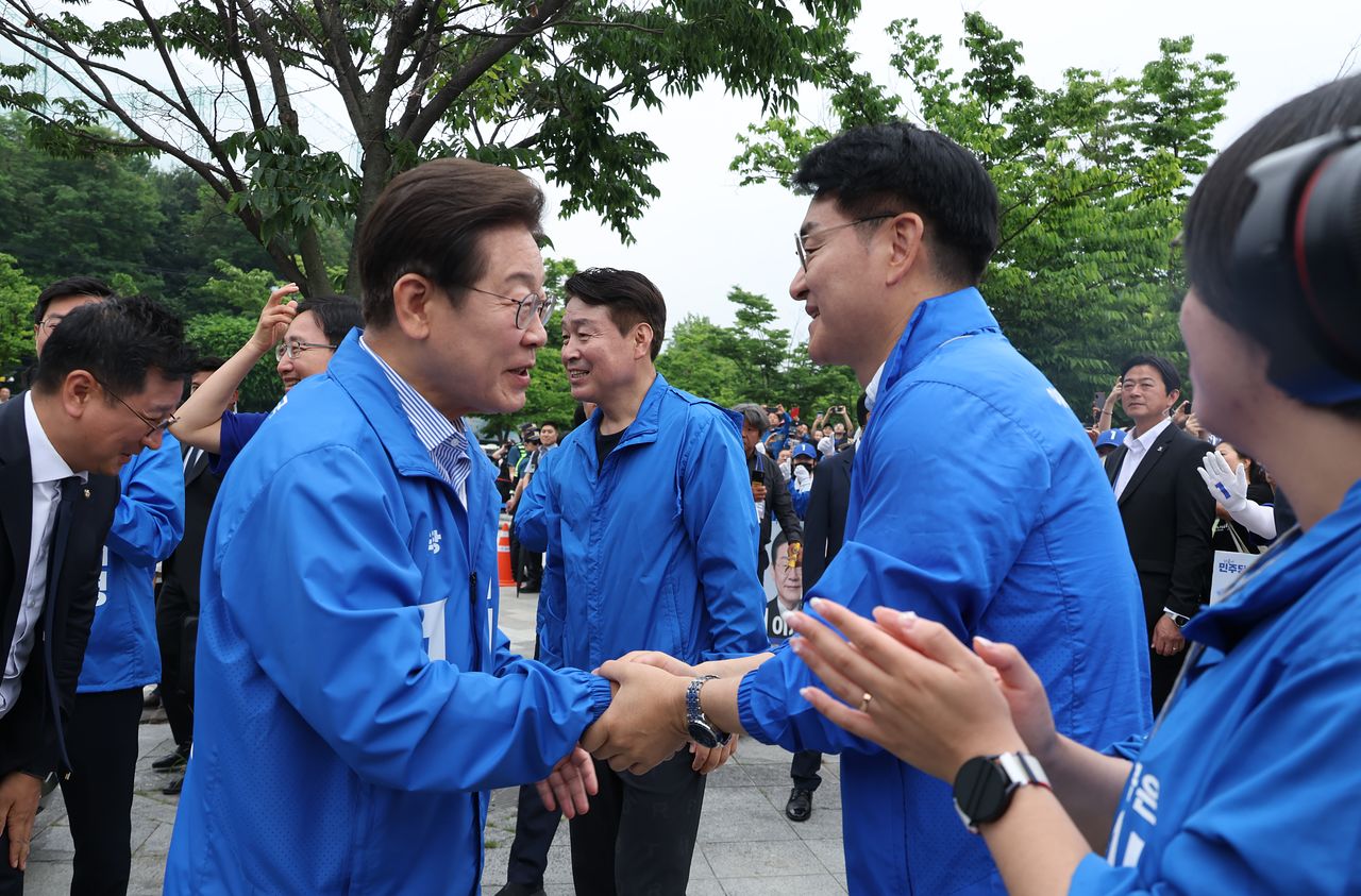 지난해 6월 2일 이재명 더불어민주당 대선 후보가 서울 북서울꿈의숲 서문광장에서 유세를 하기 전 박용진 전 의원과 인사를 하고 있다. 뉴시스