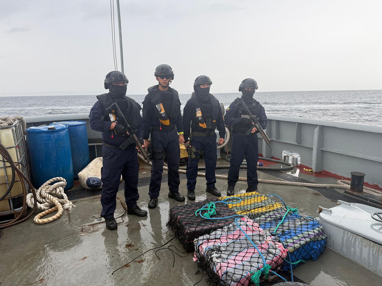지난달 23일(현지시간) 에콰도르 만타 항구에서 에콰도르 군인들이 마약 화물과 함께 체포된 에콰도르인 3명을 호송하고 있다. 에콰도르 군은 이날 태평양 연안에서 에콰도르와 미국이 약 3톤의 마약을 압수했다고 밝혔다. AFP=연합뉴스