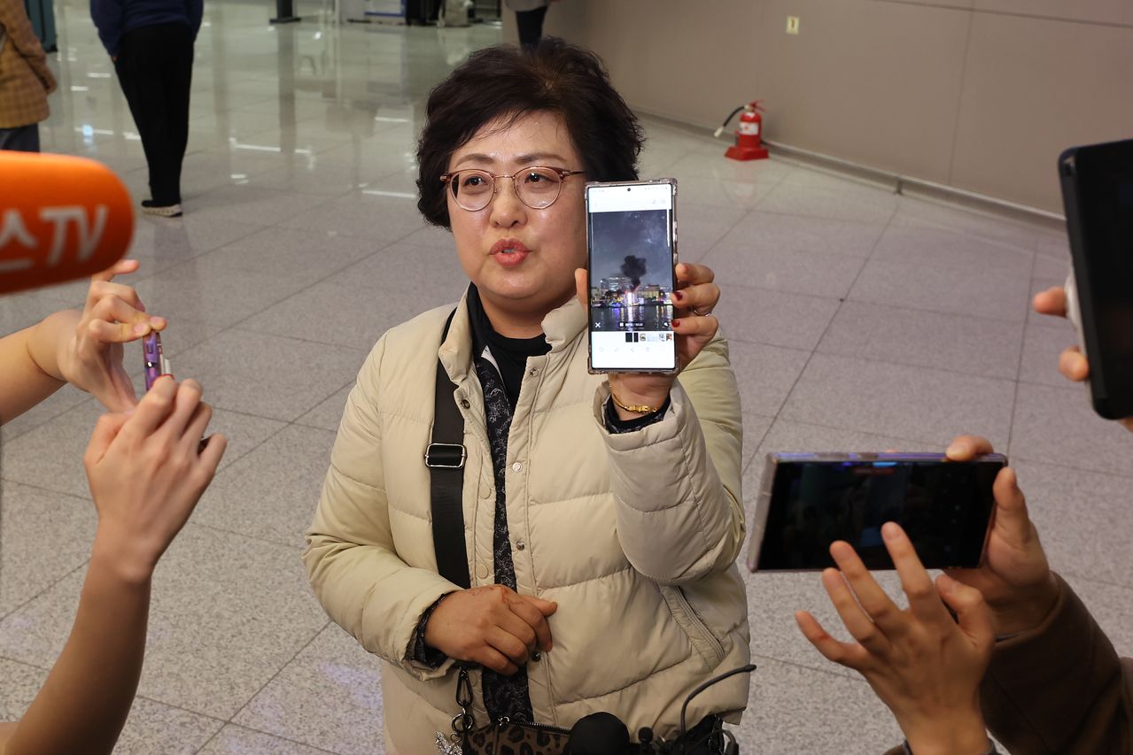 중동을 방문했다 귀국한 한 여행객이 5일 인천국제공항에서 중동 현지에서 찍은 사진을 보여주며 취재진과 인터뷰하고 있다. 연합뉴스