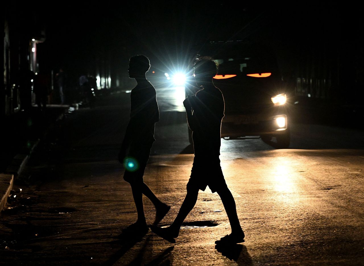 4일(현지시간) 쿠바 수도 아바나에서 정전이 발생한 가운데 사람들이 어두운 거리를 건너고 있다. AFP=연합뉴스