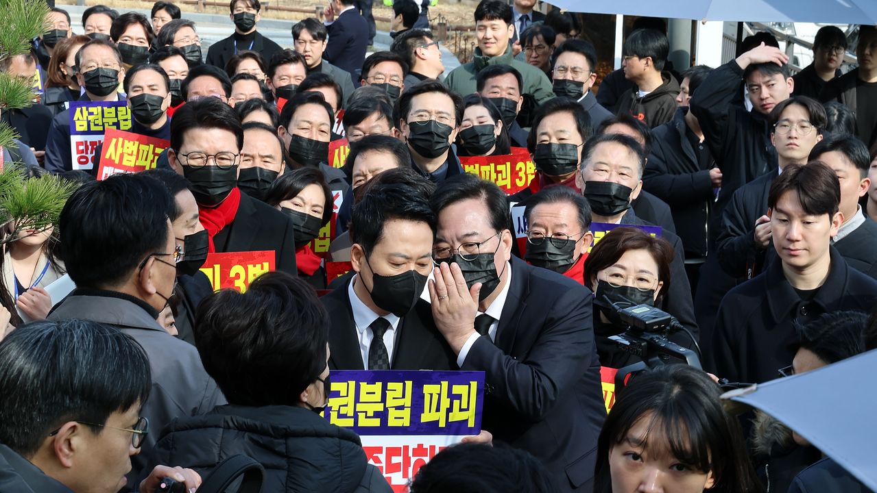 국민의힘 장동혁 대표와 송언석 원내대표가 5일 청와대 사랑채 앞에서 열린 의원총회를 마친 뒤 손팻말을 들고 청와대 방향으로 이동하던 중 경찰의 제지를 받자 대화를 나누고 있다. 연합뉴스