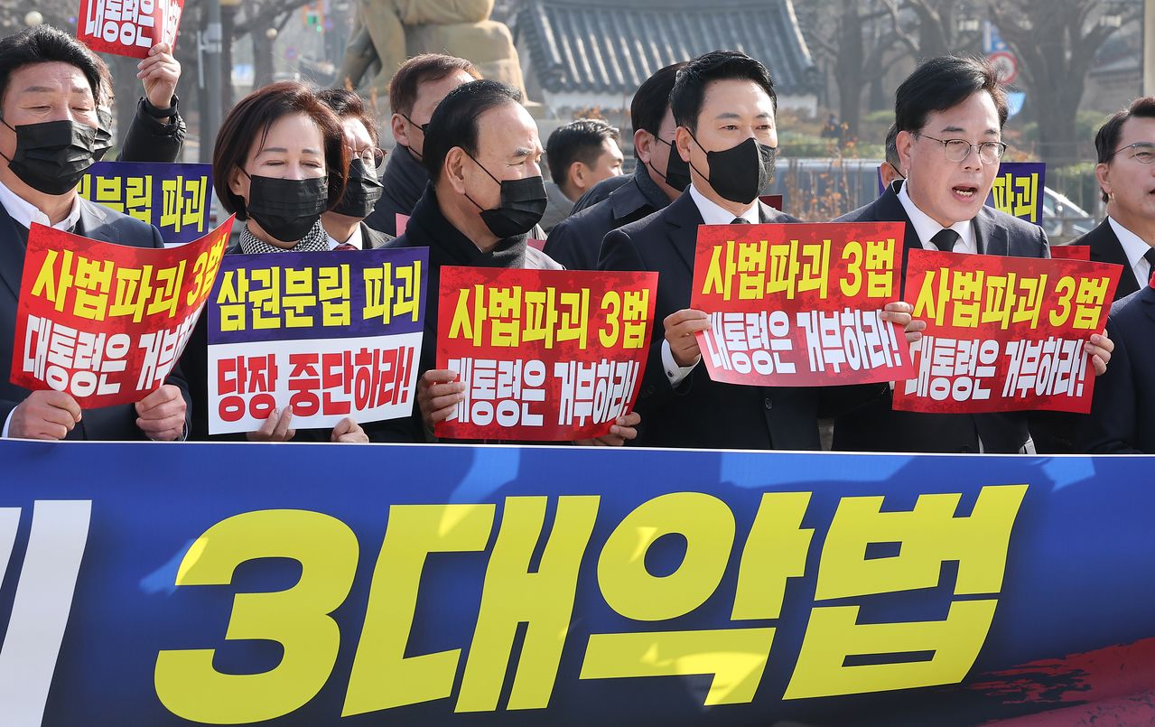 장동혁 국민의힘 대표와 송언석 원내대표를 비롯한 의원들이 5일 서울 종로구 청와대 사랑채 앞 분수대에서 열린 현장 의원총회에서 손피켓을 들고 구호를 외치고 있다. 뉴스1