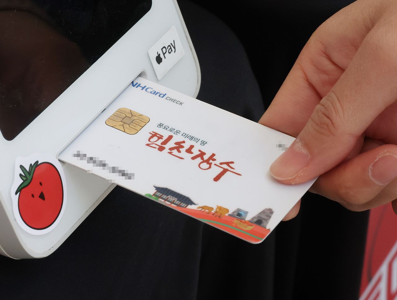 전북 장수군민에게 '농어촌 기본소득'이 처음 지급된 지난달 26일 장수군청 앞에서 진행된 상생소비 한마당에서 한 군민이 기본소득으로 물건을 구매하고 있다. 연합뉴스