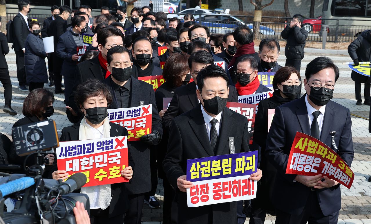 장동혁 대표와 송언석 원내대표를 비롯한 국민의힘 의원들이 5일 청와대 사랑채 앞에서 의원총회를 마친 뒤 손팻말을 들고 청와대 방향으로 이동하고 있다. 연합뉴스