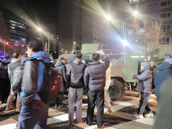 12.3 비상계엄이 해제된 2025년 12월 4일 오전 서울 여의도 국회 앞에서 시민들이 출동한 군 전술차량을 가로 막고 항의하고 있다. 중앙포토