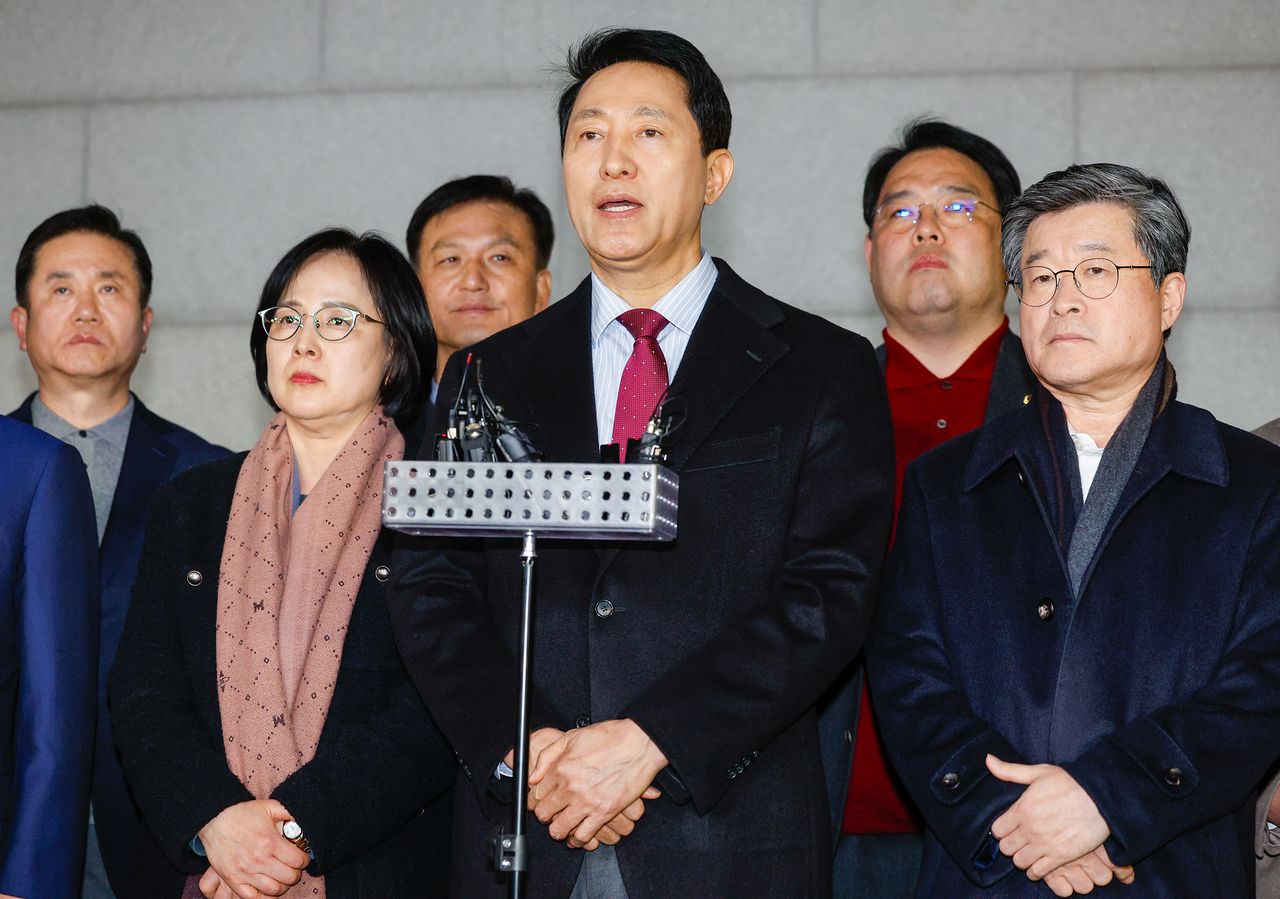 오세훈 서울시장(가운데)이 9일 저녁 서울 중구의 한 식당 앞에서 국민의힘 소속 구청장 및 시의원들과 당의 결의문 채택에 관한 입장을 발표하고 있다. 뉴스1