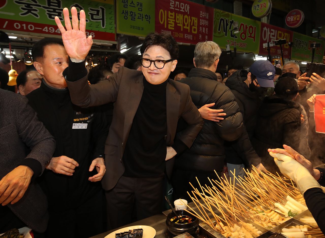 한동훈 전 국민의힘 대표가 7일 오후 부산 북구 구포시장을 찾아 지지자들에게 인사하고 있다.뉴스1