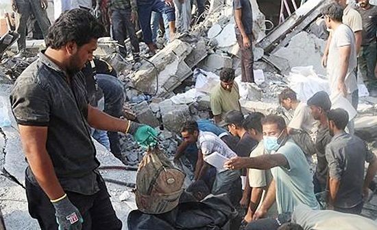 공습으로 파괴된 이란 초등학교 잔해와 구조대원들. 로이터=연합뉴스