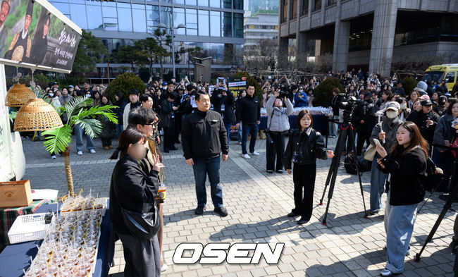 [OSEN=이대선 기자] 장항준 감독이 12일 오후 서울 중구 프레스센터 앞 광장에서 영화 '왕과 사는 남자' 흥행 감사 커피차 이벤트를 열었다.'왕과 사는 남자'는 개봉 36일째인 어제(11일) 관객수 1200만명을 넘어섰다. 이로써 '파묘'(1191만4869명)를 꺾고 역대 박스오피스 20위에 안착했다.장항준 감독이 커피차 이벤트를 진행하고 있다. 2026.03.12 /sunday@osen.co.kr