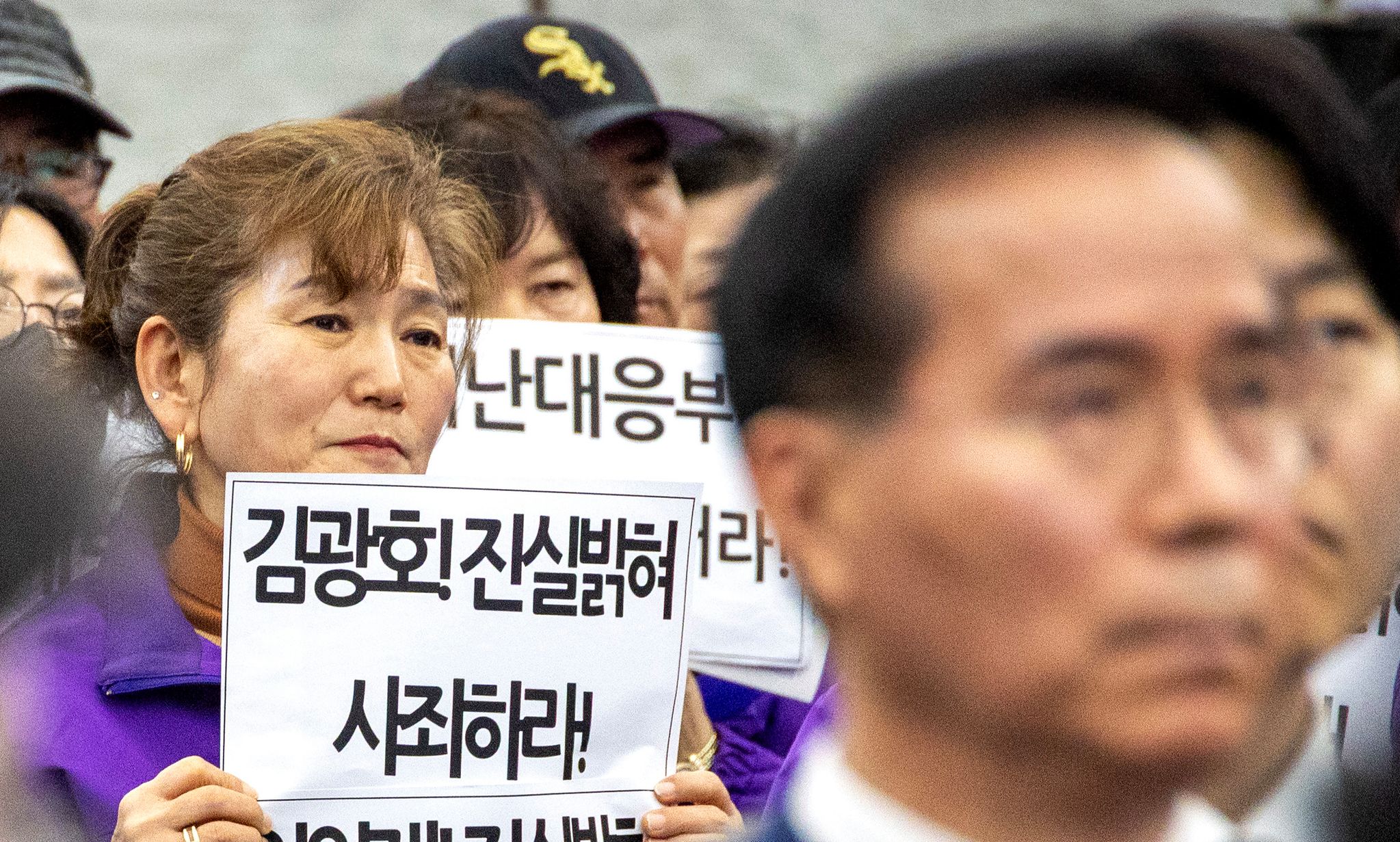 이태원참사 유가족이 김광호 전 청장의 사죄를 요구하는 손피켓을 들고 있다.