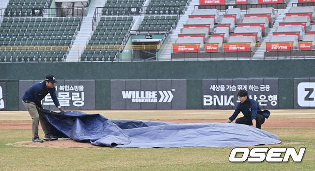 [OSEN=부산, 이석우 기자] 13일 부산 사직야구장에서 2026 신한 SOL KBO 리그 롯데 자이언츠와 KT 위즈의 시범경기가 열렸다. 홈팀 롯데는 쿄야마가 방문팀 KT는 보쉴리가 선발 출전했다.많은 비가 내리자 관계자들이 마운드에 방수포를 덮고 있다. 2026.03.13 / foto0307@osen.co.kr