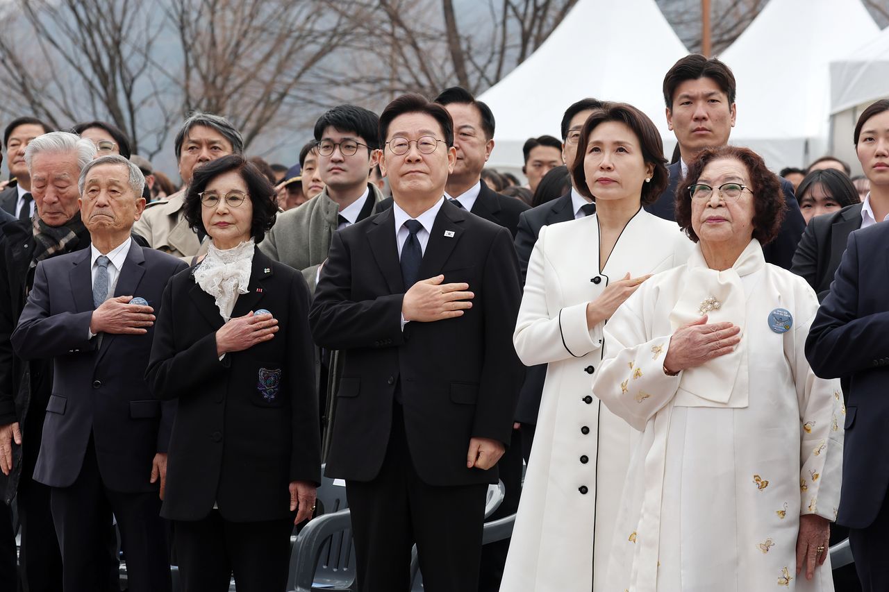 이재명 대통령과 김혜경 여사가 15일 경남 창원시 마산회원구 국립 3·15 민주 묘지에서 열린 제66주년 3·15의거 기념식에서 국기에 경례하고 있다.   지난 2010년 3·15의거가 국가기념일로 지정되고 2011년부터 정부 주관으로 기념식을 거행해 온 이래, 대통령이 참석한 것은 이번이 처음이다. 연합뉴스