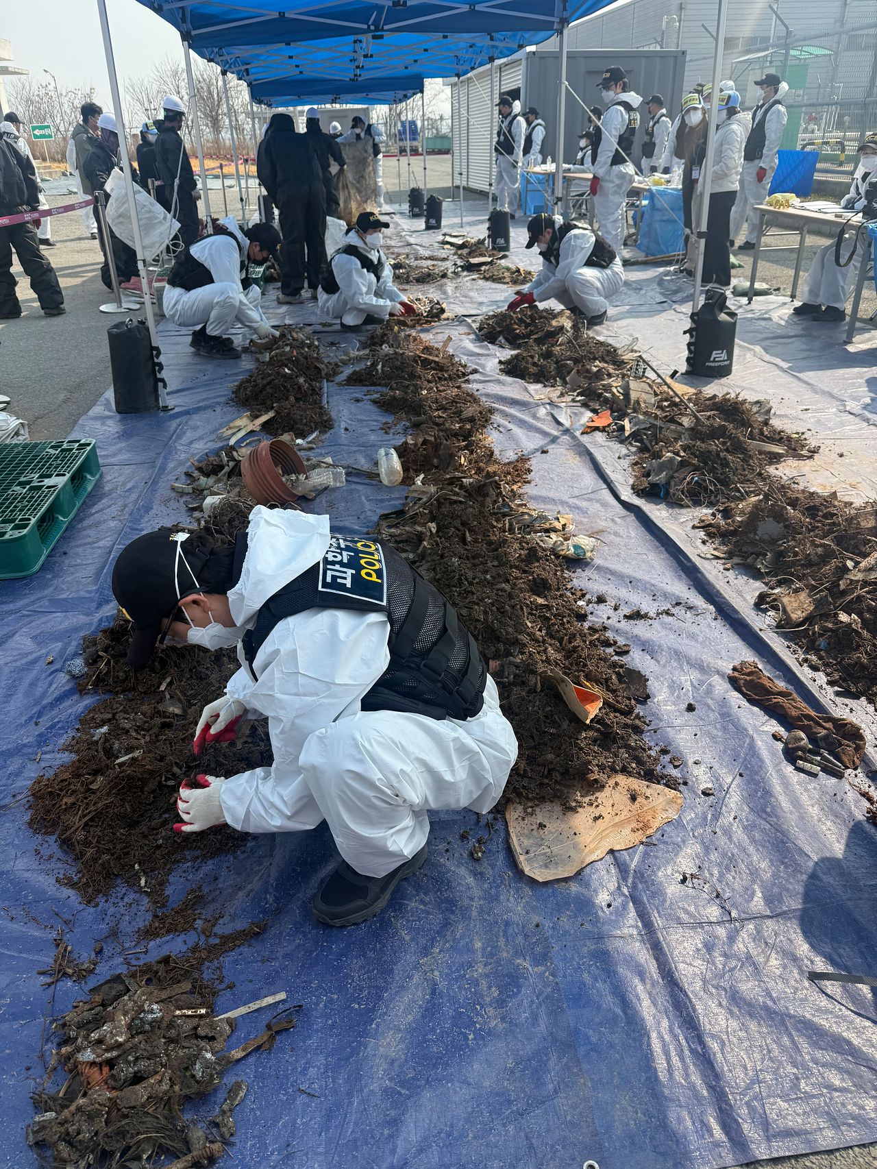 지난 12일 국토교통부와 항공철도사고조사위원회, 전남과학청 과학수사대 관계자들이 무안국제공항 공항소방대 뒤편에 보관된 여객기 잔해를 조사하고 있다. 연합뉴스