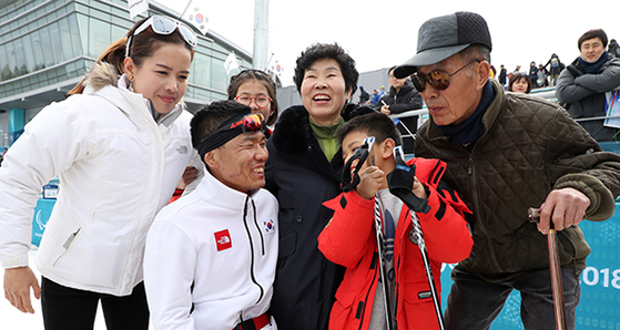 겨울패럴림픽 첫 금메달을 딴 신의현 선수가 평창 바이애슬론센터에서 가족과 웃고 있다. 신 선수를 중심으로 시계방향으로 부인 김희선씨, 딸 은겸양, 모친 이회갑씨, 부친 신만균씨, 아들 병철군. 연합뉴스