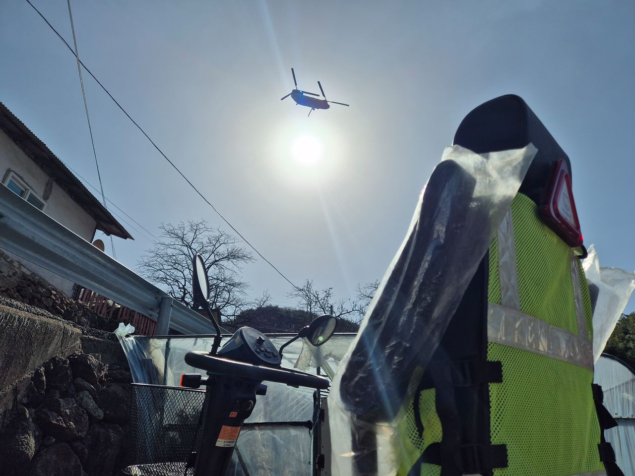 지난달 21일 경남 함양군 마천면에서 발생한 산불로 마을 주민들이 급히 대피해 텅 빈 휴천면 송전마을에 주민이 사용하던 전동보행기만 덩그러니 놓여 있다. 하늘에는 산불 진화에 나선 헬기가 날아가고 있다. 안대훈 기자