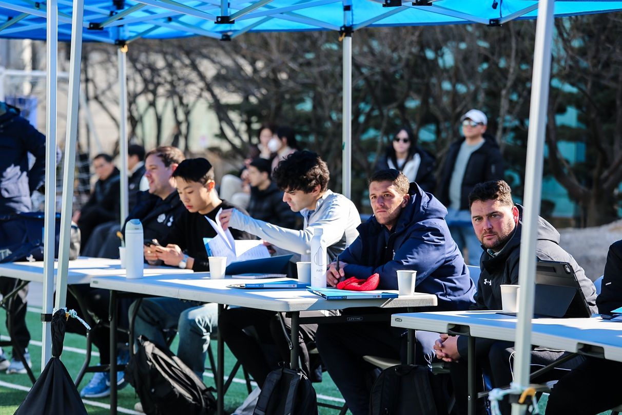 쇼케이스에 초청된 미국 대학 감독 및 코치진이 진지한 표정으로 참가 선수들의 기량을 점검하며 평가 항목을 기록하고 있다.