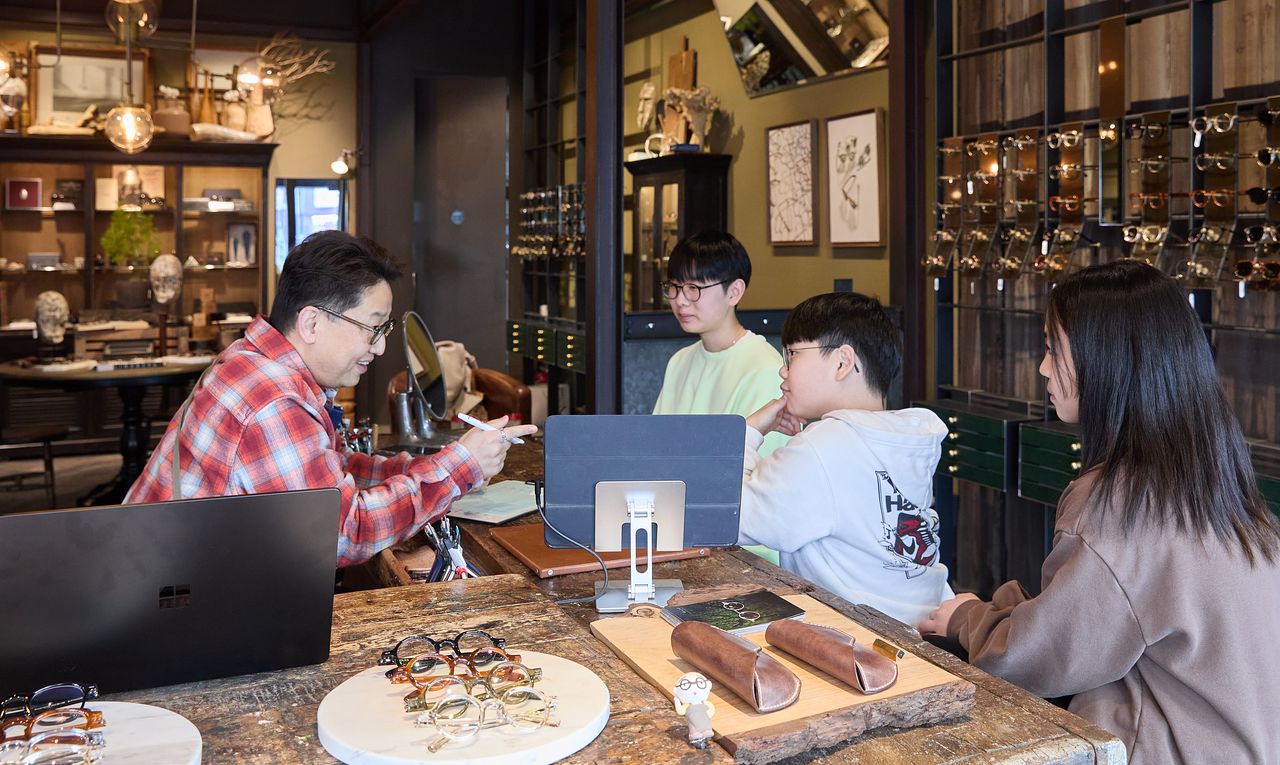 홀릭스 안경원 정병규(왼쪽) 이사가 검안 전 복용약, 눈 부상·수술 이력, 수면 시간, 운동 여부, 왜 안경을 썼는지 등을 체크하는 문진을 하고 있다.