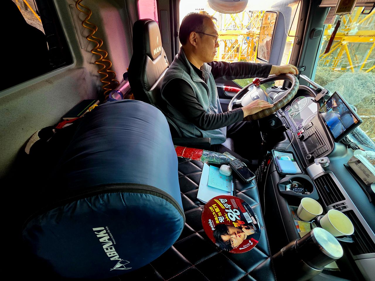 25.5톤(t) 덤프트럭 기사 김만기씨의 '또 다른 집'인 차 운전석 주변에 컵라면·침낭·보온병·칫솔 등 생활용품이 놓여 있다. 이영근 기자