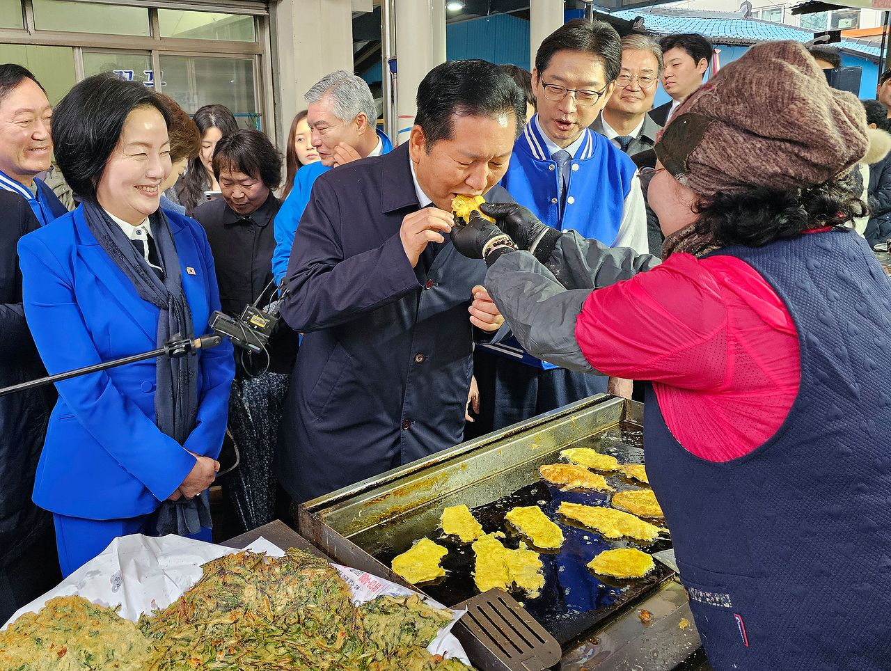 정청래 더불어민주당 대표가 18일 경남 하동군 진교공설시장을 찾아 명태전을 맛보고 있다. 뉴스1