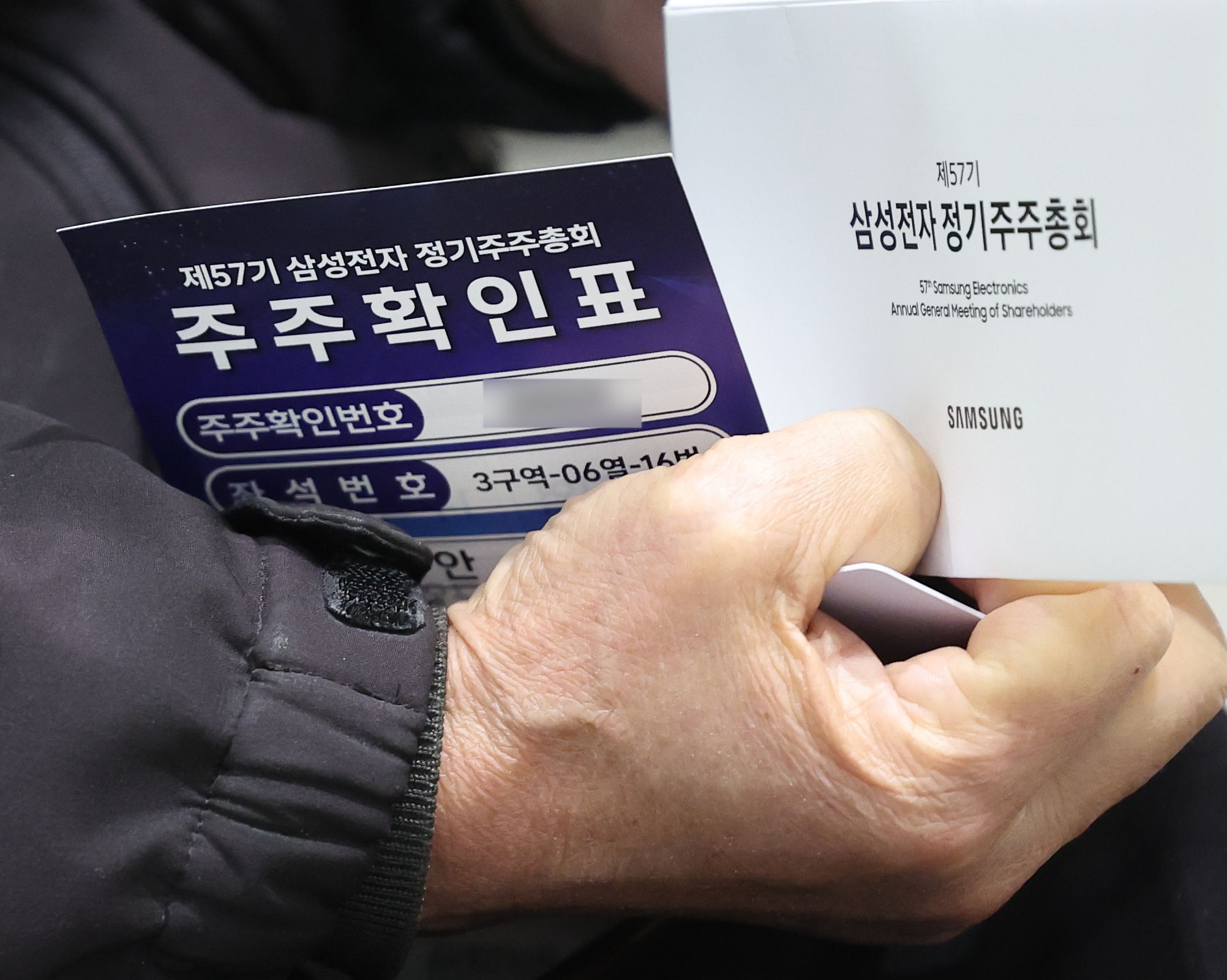 제57기 삼성전자 정기 주주총회에서 주주가 주주확인표를 들고 있다,