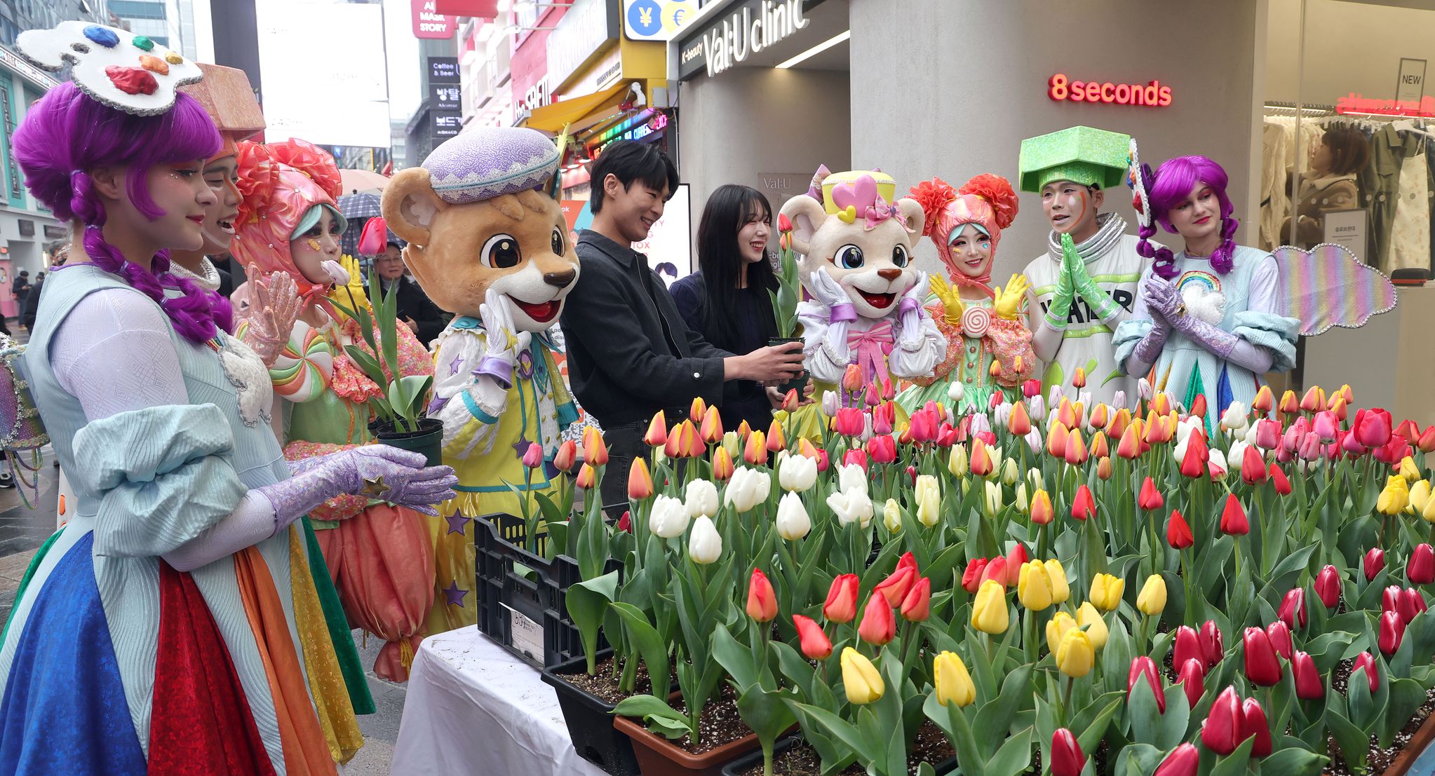 에버랜드 튤립축제 개막을 이틀 앞둔 18일 오후 서울 명동에서 공연 연기자들이 축제홍보를 위해 시민과 관광객에서 튤립을 나눠주고 있다.