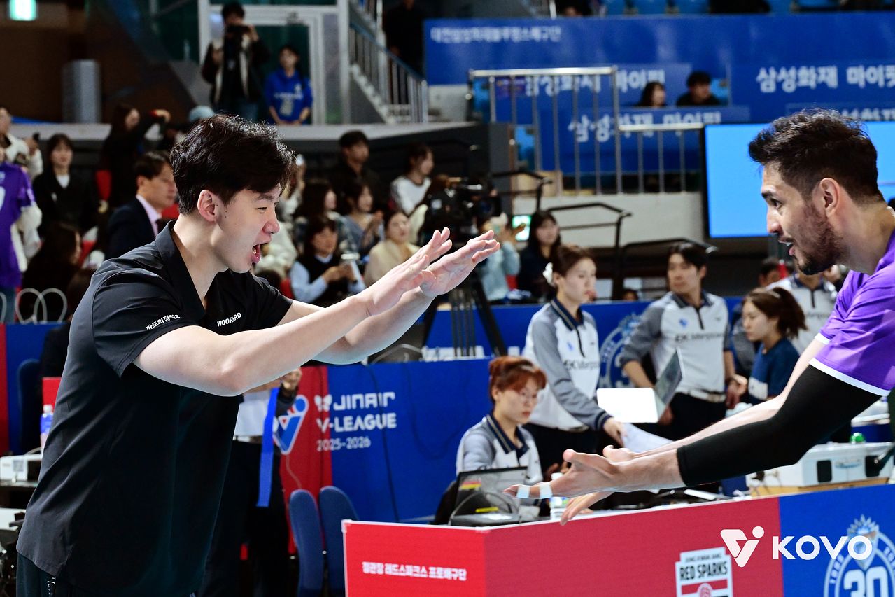 17일 대전 삼성화재전에서 승리해 준플레이오프 진출을 확정지은 우리카드 박철우 감독 대행(왼쪽)과 하이파이브하는 아라우조. 사진 한국배구연맹