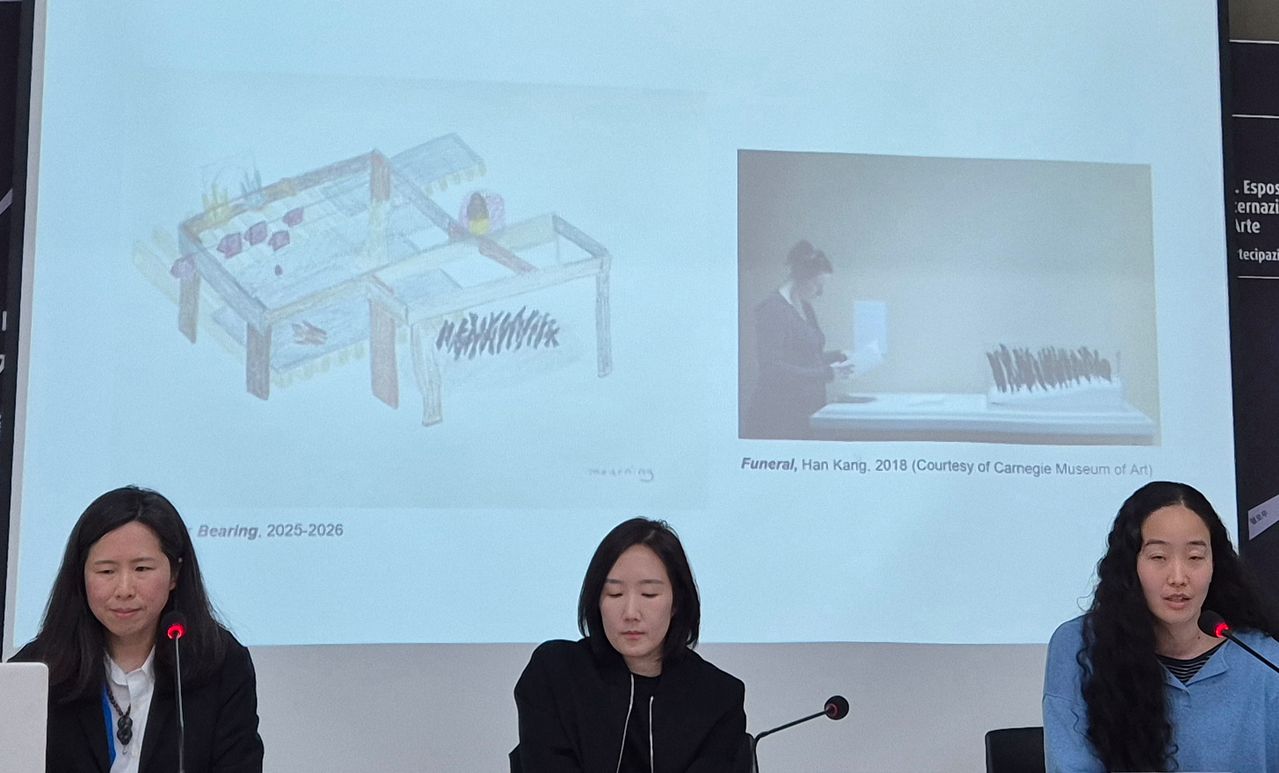 19일 서울 대학로 아르코미술관에서 2026 베니스 비엔날레 한국관 전시계획을 발표 중인 최빛나 감독(왼쪽부터)과 최고은, 노혜리 작가. 뒤 오른쪽 사진은 한강 소설가가 2018년 미국 카네미 뮤지엄에 전시한 설치 '장례'. 권근영 기자 