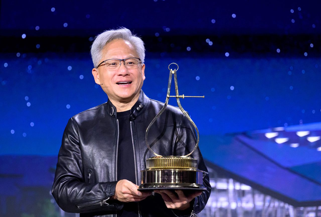 젠슨 황 엔비디아 최고경영자(CEO)가 17일(현지시간) 미국 캘리포니아 새너제이에서 열린 연례 개발자 콘퍼런스 ‘GTC 2026’에서 ‘2026 모터트렌드 올해의 인물’ 트로피를 들고 있다. AFP=연합뉴스