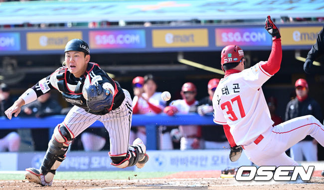 [OSEN=인천, 최규한 기자] 20일 인천 SSG랜더스필드에서 ‘2026 신한 SOL KBO리그’ 시범경기 SSG 랜더스와 LG 트윈스 경기가 열렸다.홈팀 SSG는 김민준, 방문팀 LG는 요니 치리노스를 선발로 내세웠다.5회말 1사 만루 상황 SSG 고명준의 1타점 희생플라이 때 LG 포수 이주헌이 악송구에 3루 주자 오태곤의 홈 태그업을 허용하고 있다. 2026.03.20 / dreamer@osen.co.kr