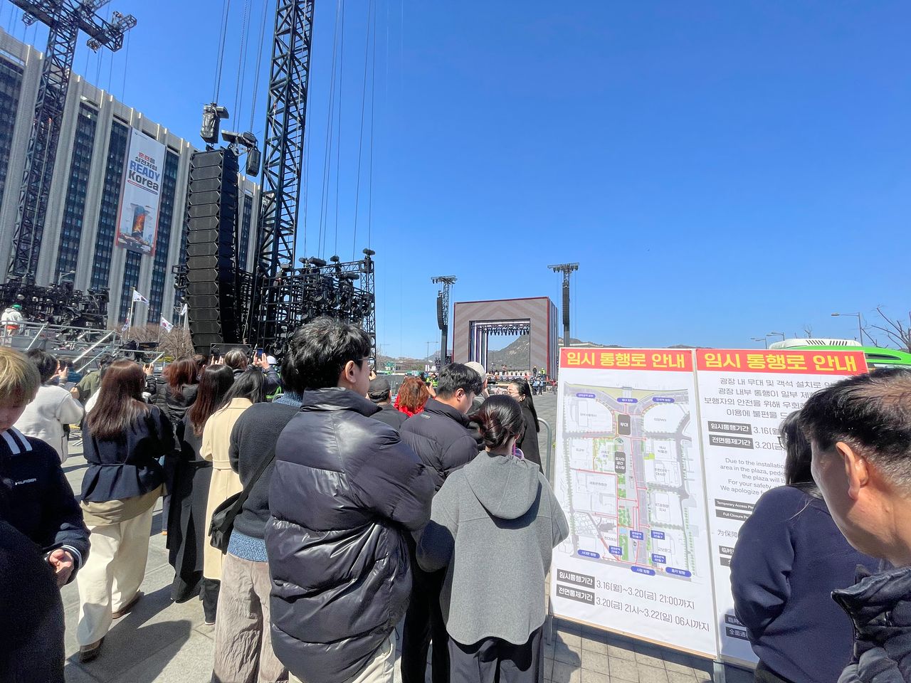 19일 낮 12시쯤 광화문광장에서 21일 열릴 방탄소년단(BTS) 컴백공연 준비 현장을 지켜보는 시민들. 김예정 기자 