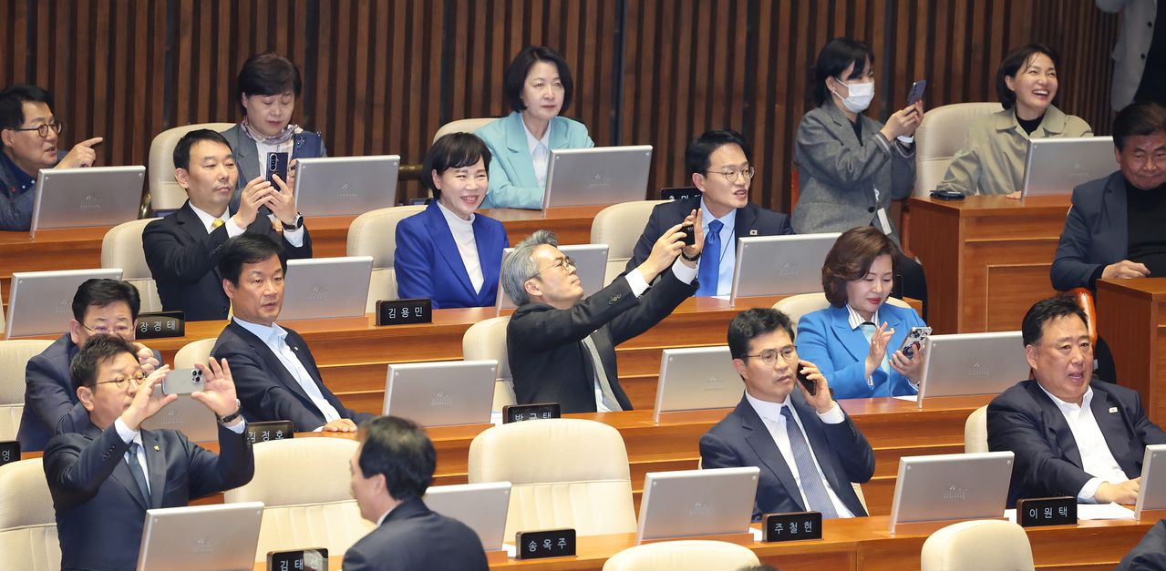 김용민 의원을 비롯한 더불어민주당 의원들이 20일 서울 여의도 국회에서 열린 제433회국회(임시회) 제2차 본회의에서 공소청법안(대안)이 가결되는 순간을 사진으로 남기고 있다. 뉴스1 