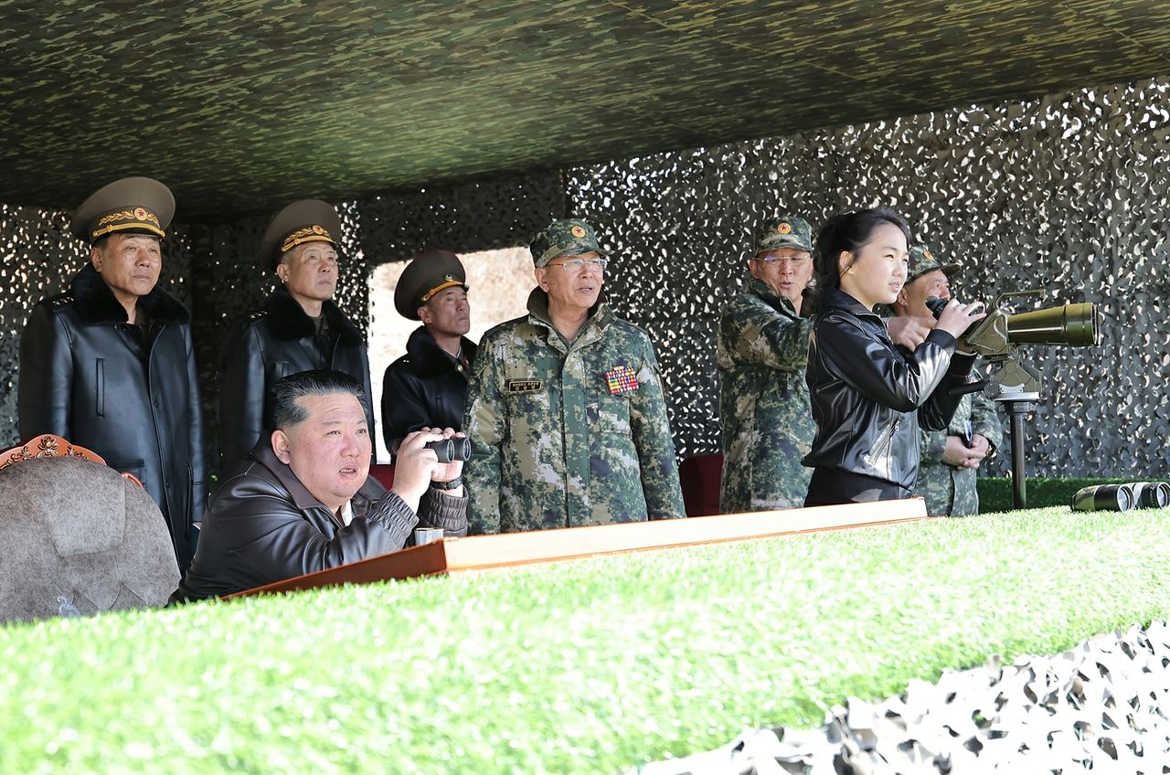 김정은 북한 국무위원장과 딸 주애가 지난 19일 북한군 수도방어군단직속 평양 제60훈련기지에서 진행하는 보병, 전차병구분대들이 협동공격전술연습을 쌍안경으로 참관하는 모습. 노동신문, 뉴스1 