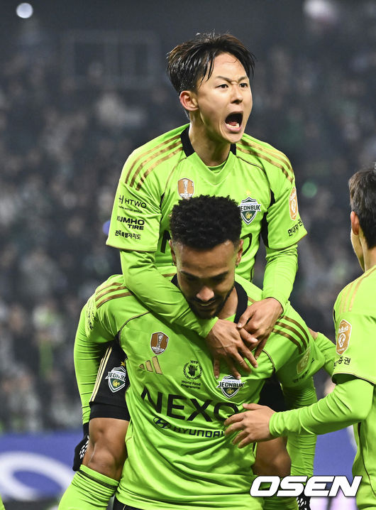 [OSEN=전주, 박준형 기자] 18일 전북 전주월드컵경기장에서 '하나은행 K리그1 2026'전북 현대와 FC안양의 경기가 진행됐다.  FC안양은 개막 3경기 무패로 상승세를 이어가고 있고 3위에 랭크됐다. 반면 디펜딩 챔프 전북 현대는 시즌 첫 승을 위해 3전 4기에 도전한다.후반 전북 현대 이승우가 역전골 넣은 모따의 등에 업혀 기뻐하고 있다.  2026.03.18 / soul1014@osen.co.kr