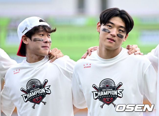 [OSEN=인천, 최규한 기자] 프로야구 KIA 타이거즈가 정규시즌에서 우승을 거머쥐었다.정규시즌 우승까지 매직넘버 1을 남겨두고 있던 KIA는 이날 경기에서 승리하거나 서울 잠실구장에서 열린 두산과 삼성의 경기에서 삼성이 패하면 우승을 확정할 수 있었다. 자력우승에 도전했던 KIA는 SSG에 패하며 자력우승을 하지는 못했지만 두산이 삼성을 8-4로 격파하면서 마지막 매직넘버를 줄이고 정규시즌 우승을 확정했다. 1991년, 1993년, 1996~1997년, 2009년, 2017년에 이은 구단 역대 7번째 우승이다.KIA 김도영(오른쪽)과 박찬호를 비롯한 선수들이 우승을 기뻐하고 있다. 2024.09.17 / dreamer@osen.co.kr