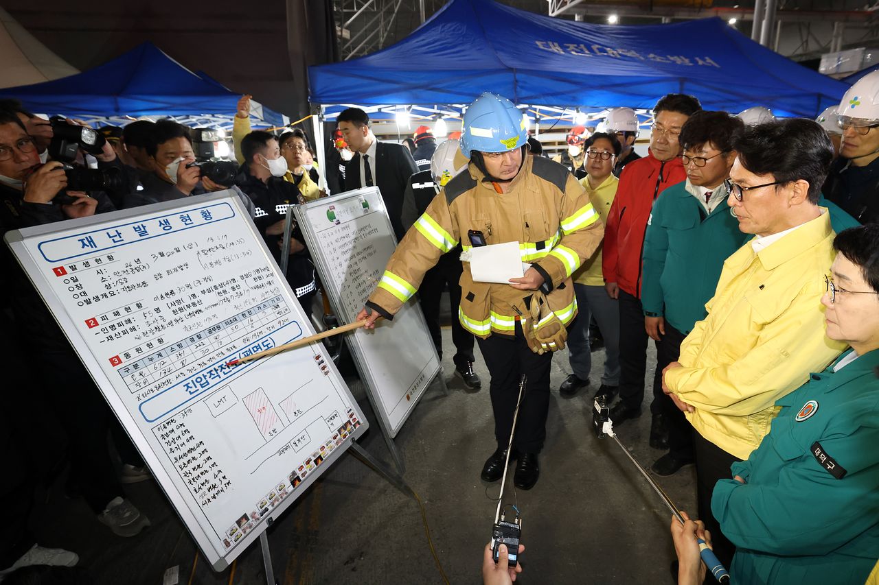 김민석 국무총리가 20일 화재가 발생한 대전 대덕구 문평동 자동차부품 제조 공장을 찾아 남득우 대전 대덕소방서장으로부터 화재 현황을 보고 받고 있다. 뉴스1