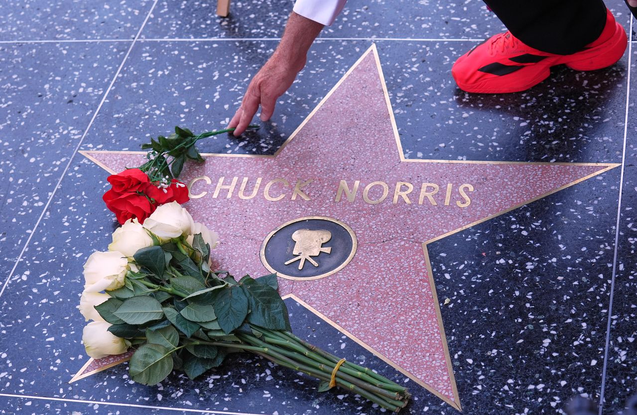 지난 20일(현지시간) 미국 로스앤젤레스 할리우드 명예의 거리에서 시민들이 최근 별세한 배우 척 노리스의 스타 앞에 장미꽃을 놓고 추모하고 있다. AP=연합뉴스