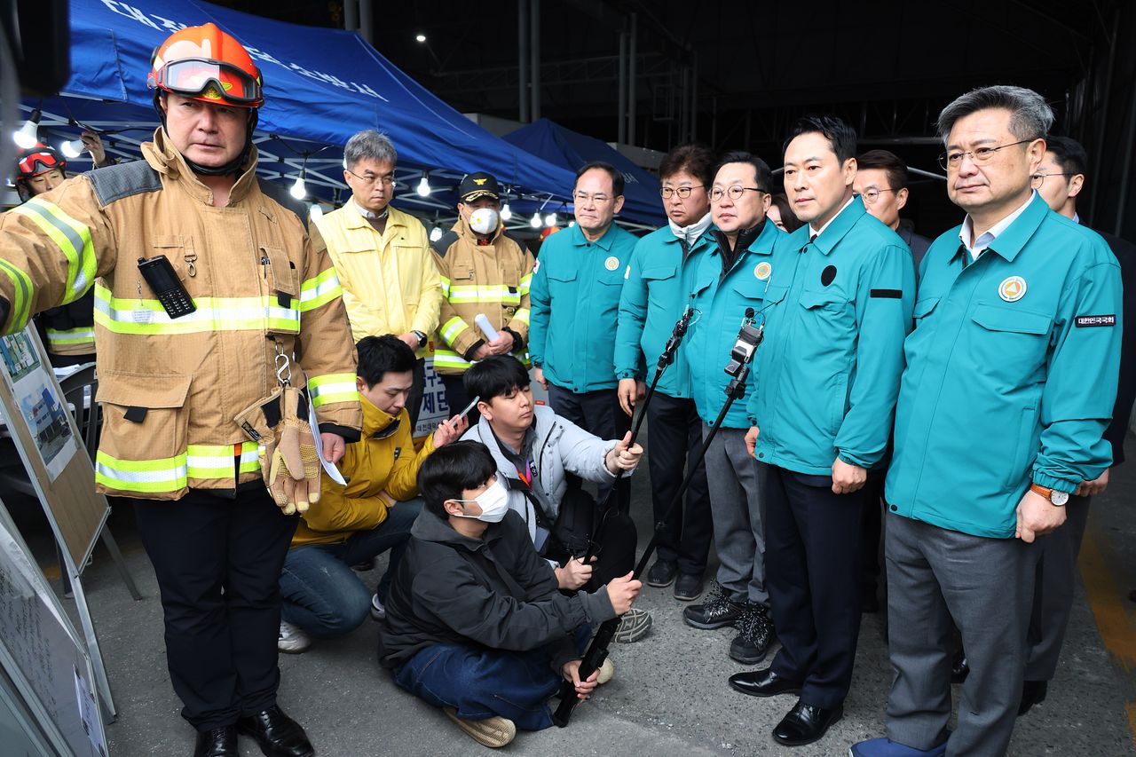 장동혁 국민의힘 대표가 21일 대형 화재로 인명피해가 발생한 대전 대덕구 자동차 부품 제조 공장을 찾아 현장에 대한 설명을 듣고 있다. 뉴스1