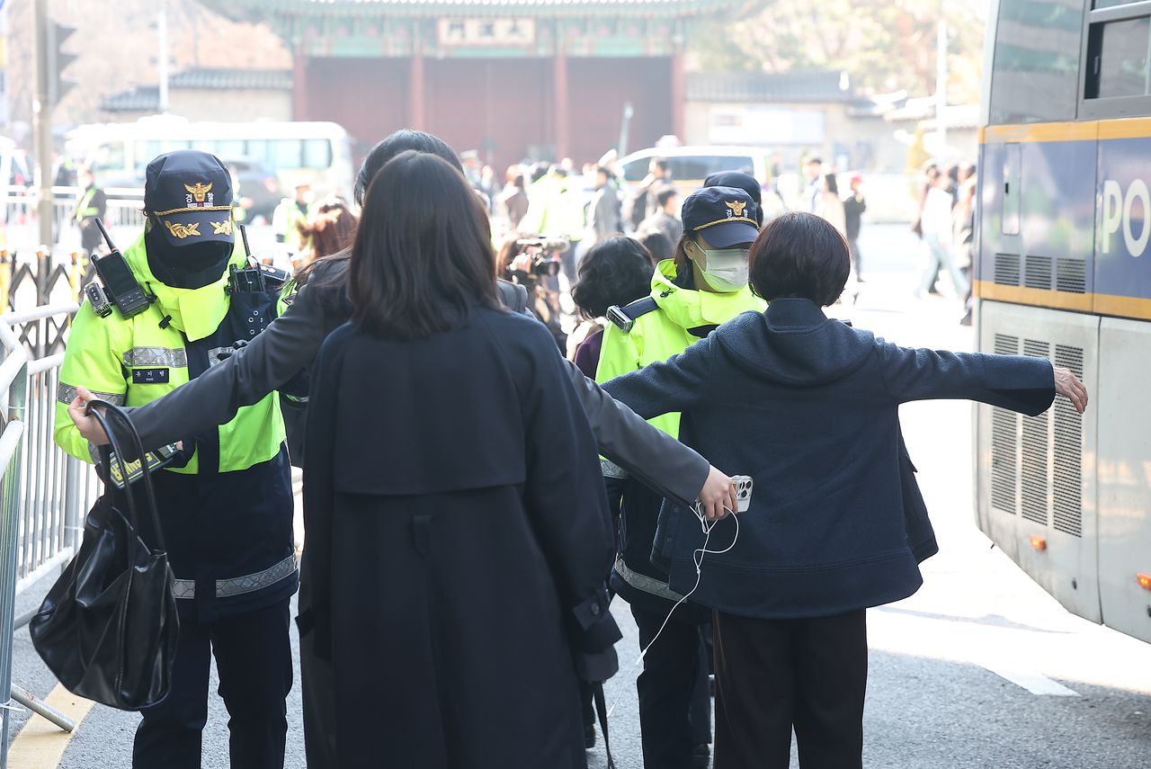 방탄소년단(BTS) 공연이 열리는 21일 서울 광화문 광장 인근 결혼식장을 방문한 하객들이 버스에서 내려 검문검색을 받고 있다. 연합뉴스