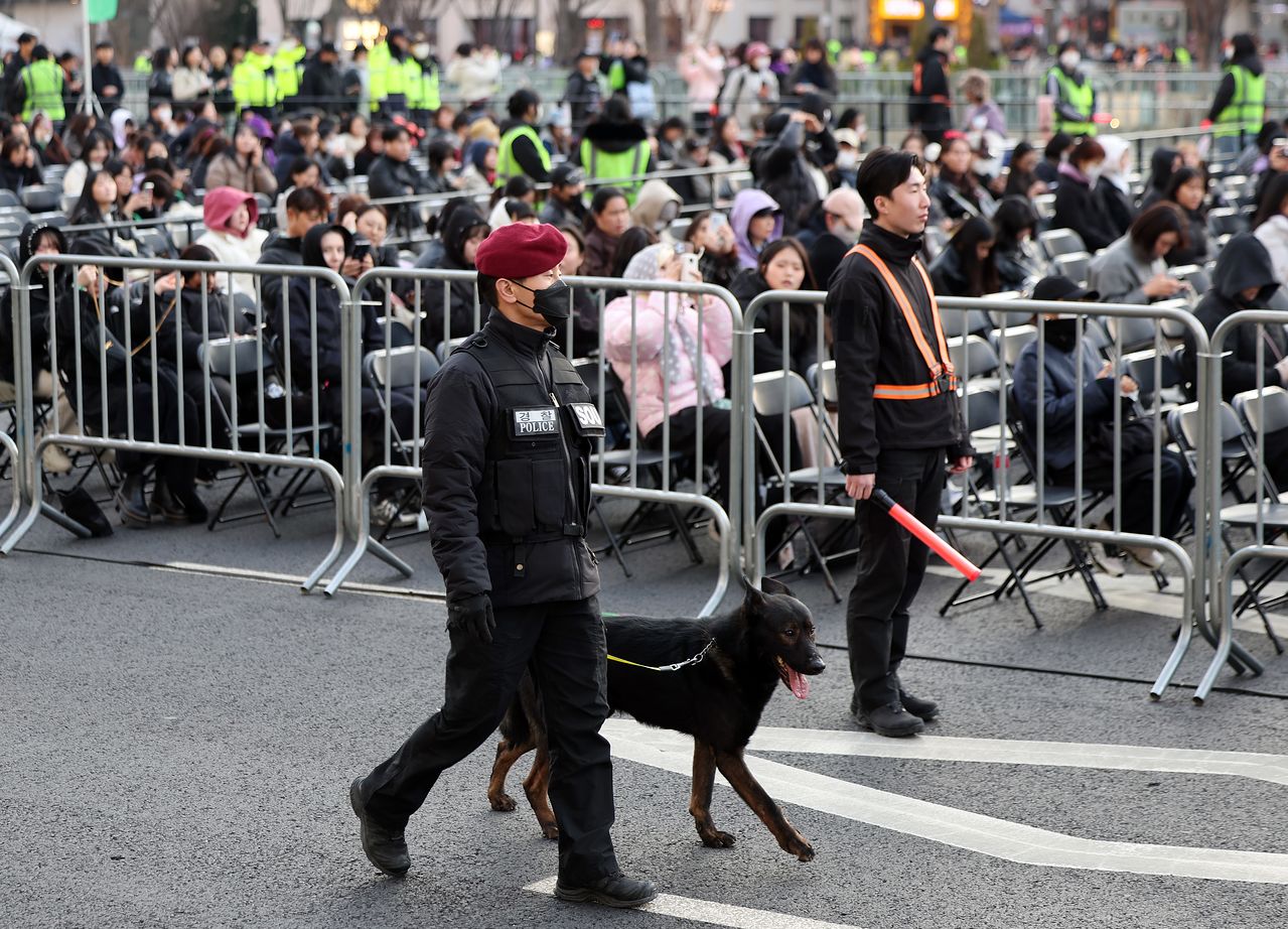 방탄소년단(BTS) 컴백 공연일인 21일 오후 서울 종로구 광화문광장에서 경찰특공대 대원이 폭발물 탐지견을 동원해 위험물을 수색하고 있다. 뉴스1