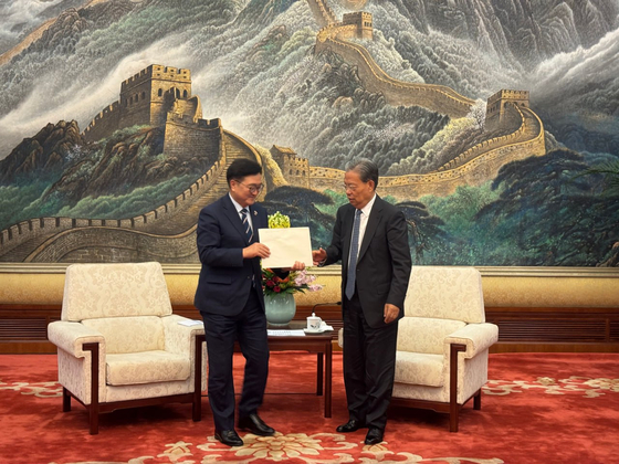 우원식 국회의장이 지난해 9월 4일 오전(현지시각) 중국 베이징 인민대회당에서 자오러지 전인대 상무위원장을 만나 중국에 진출한 한국 기업들의 애로사항 10여개를 정리한 문건을 직접 전달하고 있다.연합뉴스
