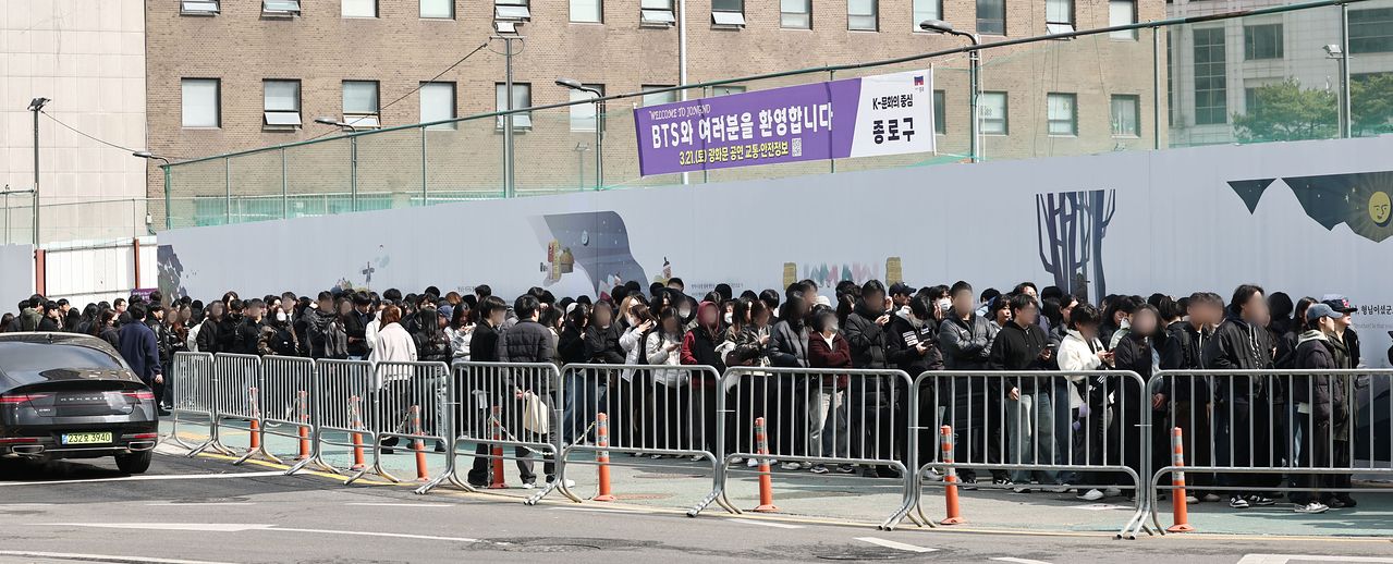 그룹 방탄소년단(BTS)의 컴백 공연을 하루 앞둔 20일 서울 종로구청 부지 앞에서 행사 당일 단기 아르바이트로 진행요원을 맡은 시민들이 교육을 위해 줄을 서고 있다. 연합뉴스