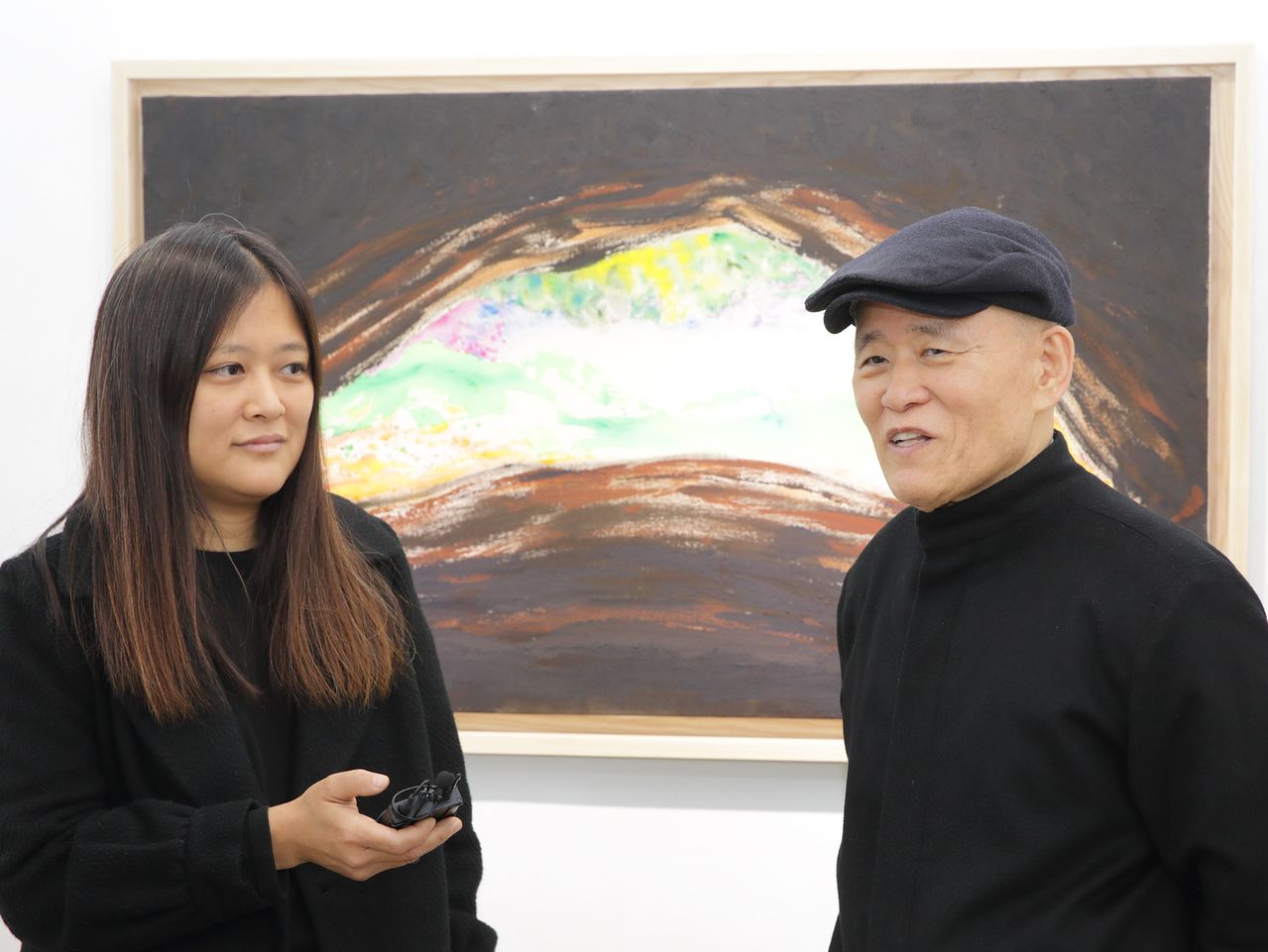 서울 인사동 갤러리 루벤에서 31일까지 '도올 문인화전'과 '김미루 회화전: 마야는 살아있다'를 여는 철학자 도올 김용옥(오른쪽)과 딸 김미루. 뒤의 그림은 김미루의 '아크툰 우실 성혈 입구', 정글 속 긴 세노테(싱크홀 샘)의 안에서 본 바깥 세상을 그렸다. 사진 유튜브 도올TV