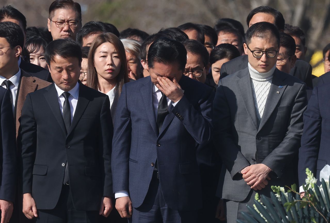 정청래 더불어민주당 대표가 23일 오전 경남 김해시 진영읍 봉하마을 노무현 전 대통령 묘역을 참배하며 눈물을 흘리고 있다. 왼쪽은 한병도 민주당 원내대표, 오른쪽은 김상욱 울산시장 후보. 연합뉴스