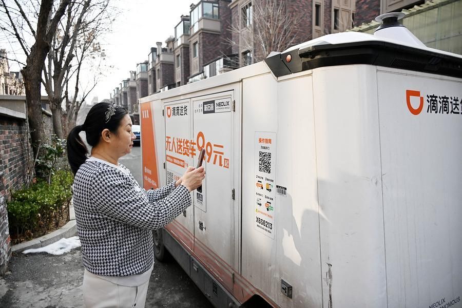  1월 28일 산둥(山東)성 칭다오(青島)시의 한 단지에서 지역 주민 저우리(周莉)가 휴대전화로 QR코드를 스캔해 물품을 수령하고 있다. 신화통신