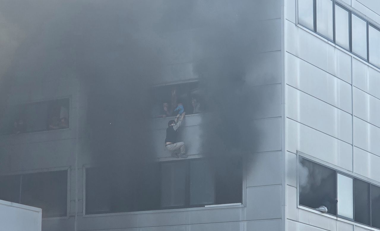 지난 20일 대전시 대덕구 문평동 자동차 부품 공장에서 화재가 발생하자 건물 2층에 있던 직원들이 창문에 매달려 구조를 기다리고 있다. [사진 한서현씨]