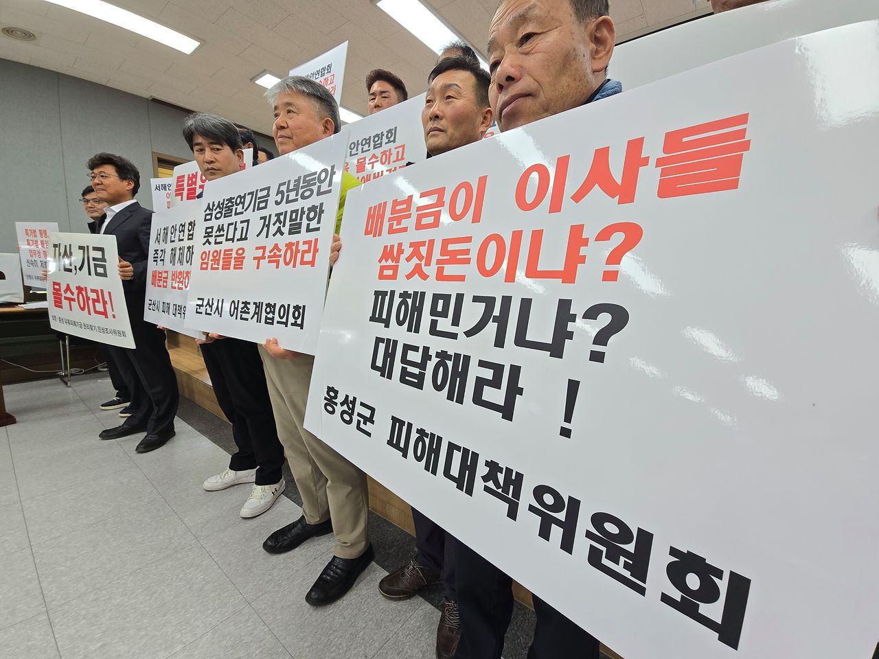 충남 보령·홍성, 전북 군산·부안, 전남 무안·영광 등지에서 모인 어민들이 지난 22일 수협중앙회 충청지부에서 열린 서해안연합회 유류피해기금 권리찾기 진상조사위원회 3차 총회에 참석해 피켓을 들고 있다. 손성배 기자