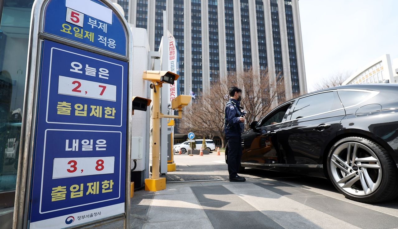정부가 ‘공공 부문 승용차 5부제(요일제)’를 오늘(25일)부터 의무화하기로 했다. 친환경 자동차, 장애인 사용 승용차, 임산부·유아 동승 차량은 제외하고, 네 차례 이상 부제를 어기는 공무원은 징계도 할 방침이다. 24일 정부서울청사 정문에 관련 안내문이 부착돼 있다. [뉴시스]