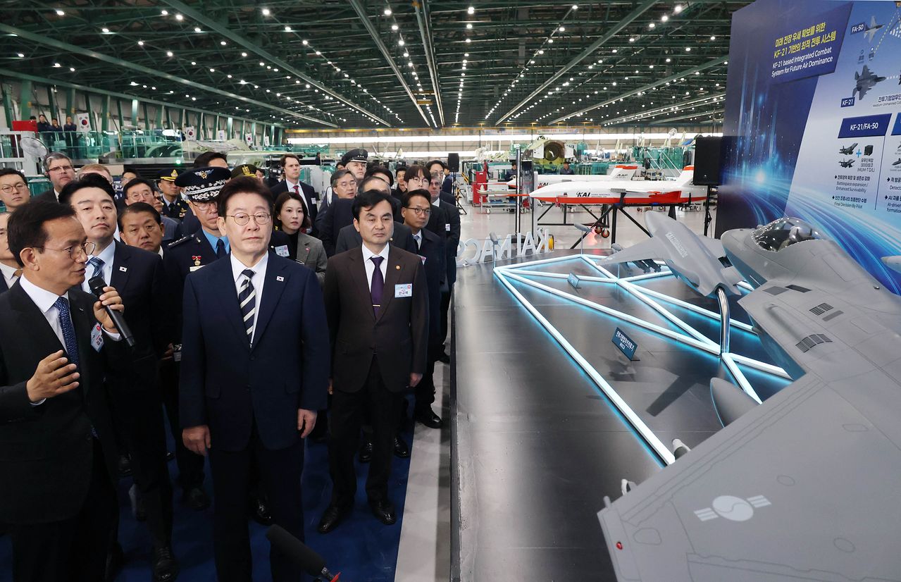  이재명 대통령이 25일 오후 경남 사천 한국항공우주산업(KAI)에서 KF-21 양산 1호기 출고식을 마친 뒤 관계자들과 생산 현장 시찰을 하고 있다. 청와대사진기자단